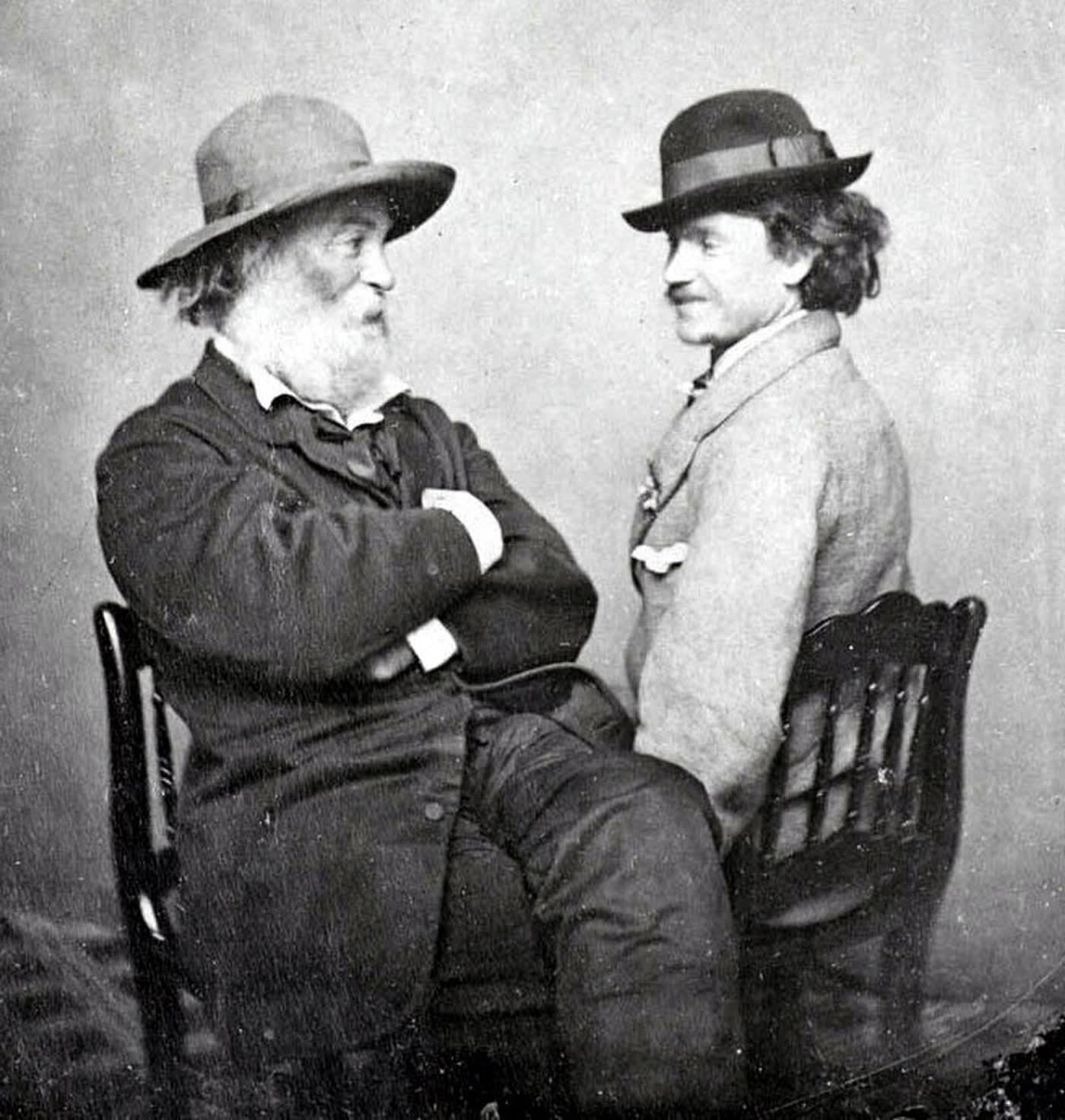 Walt Whitman and Peter Doyle seated together in a studio, looking at each other, ca. 1869.